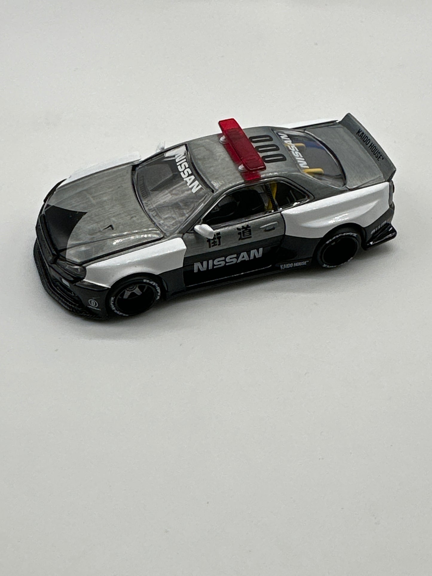 Kaido House (x MiniGT) - Chase Release #120 - White Nissan Skyline GT-R (R34) Kaido Works V2 Aero (Japan Police)