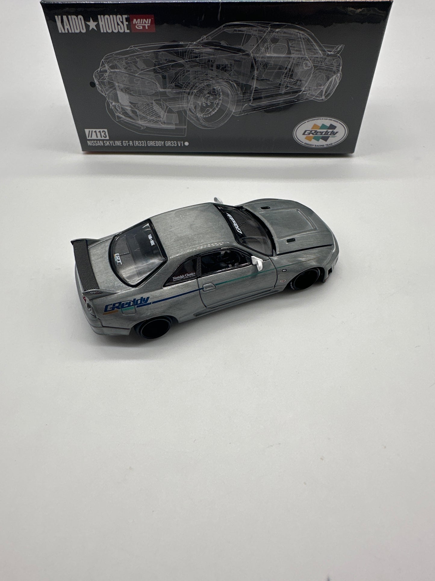 Kaido House (x MiniGT) - Raw Chase #113 - White Nissan Skyline GT-R (R33) GReddy V1